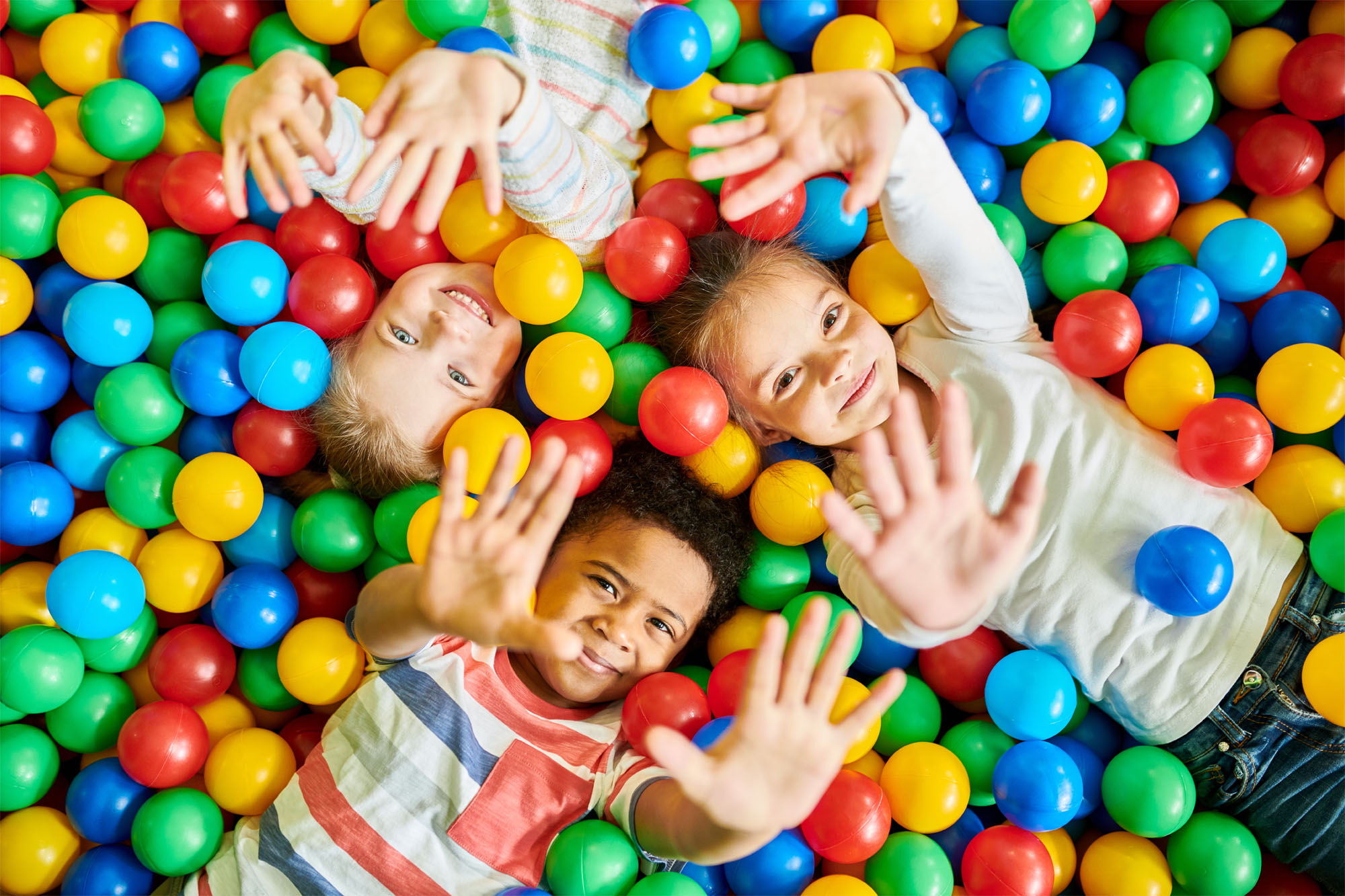 children laying down in ball pit