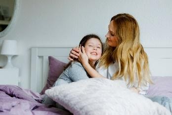 mother hugging daughter in bed
