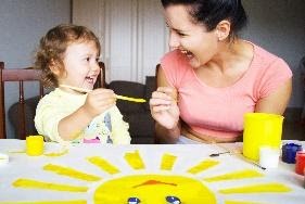 little girl painting with woman